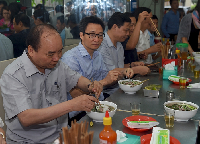 Thủ tướng và đoàn kiểm tra dừng chân, dùng điểm tâm tại một quán ăn đường phố thuộc phường Tân Thành, TPHCM. Ảnh: VGP/Quang Hiếu