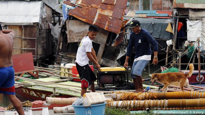 
Ngư dân thu dọn sau bão Sarika Ảnh: DPA
