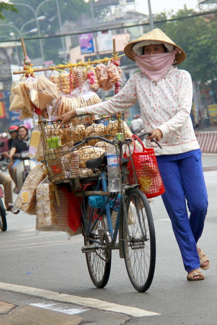Chị bán bánh dạo với xe bán các loại bánh bình dân, trong đó có bánh chao - Ảnh: BẢO KHÔI