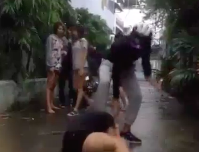 
Nhí Tinô (Mặc áo đen) đang đạp vào đầu và đánh một nữ sinh khác ở huyện Nhà Bè (TP HCM)
