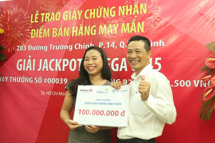 Đại diện công ty TNHH MTV Đầu Tư Cỏ Bốn Lá trao thưởng 100 triệu đồng cho chủ quầy 283 Trường Chinh (quận Tân Bình, TP.HCM). Ảnh: Phạm Oanh.