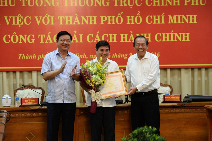 Phó Thủ tướng Thường trực Trương Hòa Bình (bìa phải) trao bằng khen của Thủ tướng Chính phủ cho UBND TP HCM về thành tích cải cách hành chínhẢnh: TRƯỜNG HOÀNG