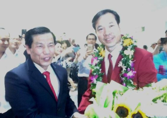 Bộ trưởng Nguyễn Ngọc Thiện trao cho xạ thủ Hoàng Xuân Vinh bó hoa chúc mừng