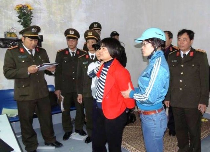 Trần Thị Nga (áo đỏ) đang được Công an tỉnh Hà Nam đọc lệnh thi hành bắt tạm giam