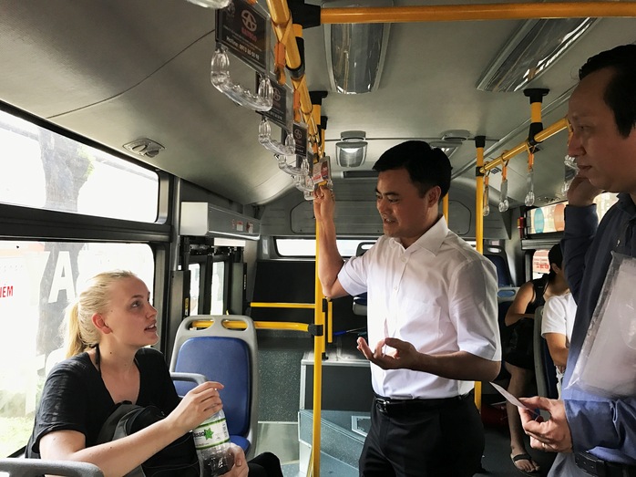 Ông Bùi Xuân Cương trò chuyện vui vẻ với nữ du khách trên xe buýt