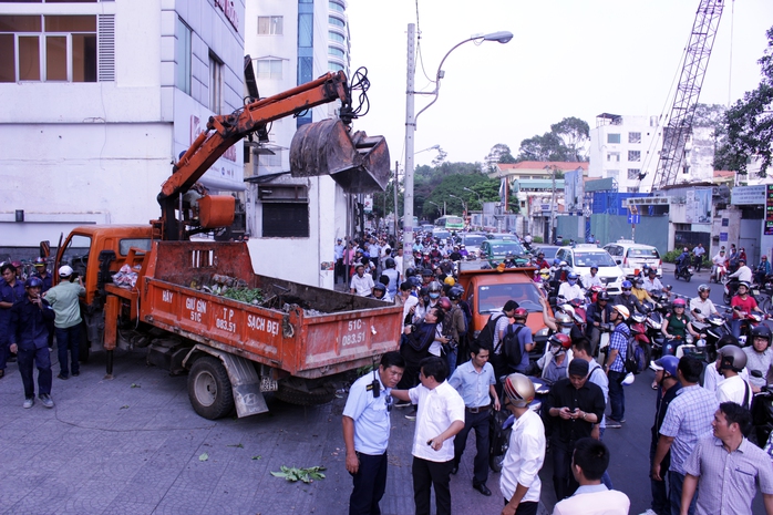 
Trên đường Nguyễn Thị Minh Khai, thấy 1 bức tường và 1 bồn cây sứ trước cổng Bộ Công Thương phía Nam lấn chiếm vỉa hè, đoàn kiểm tra đập bỏ, tháo dỡ.
