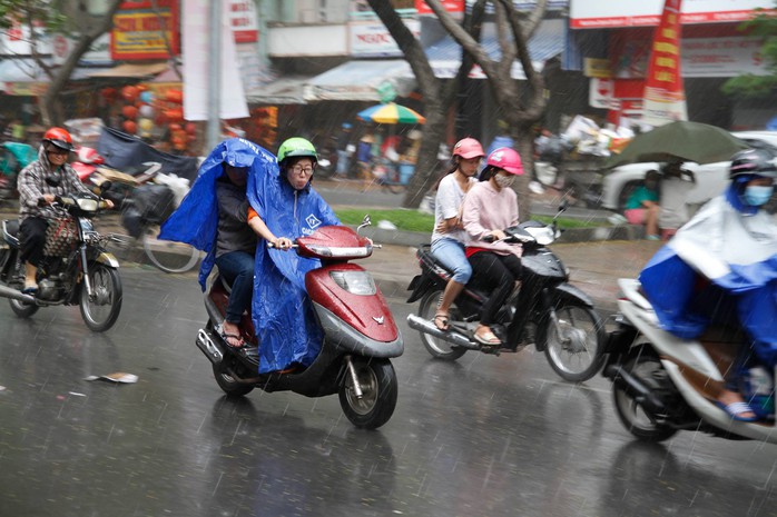 
Nhiều người vội vã lưu thông trong cơn mưa chiều 25-1
