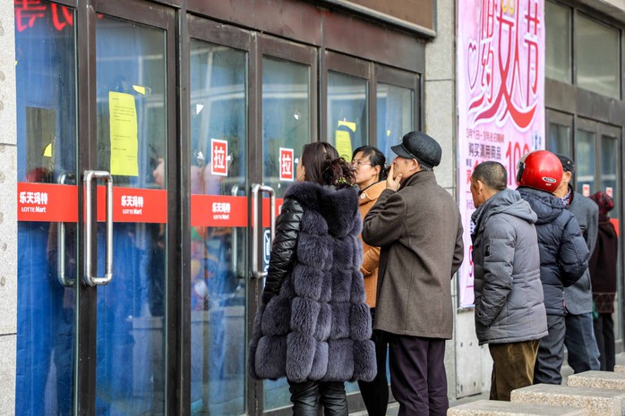 Người dân nhìn vào bên trong cửa hàng Lotte Mart bị đóng cửa ở TP Đan Đông, tỉnh Liêu NinhẢnh: REUTERS