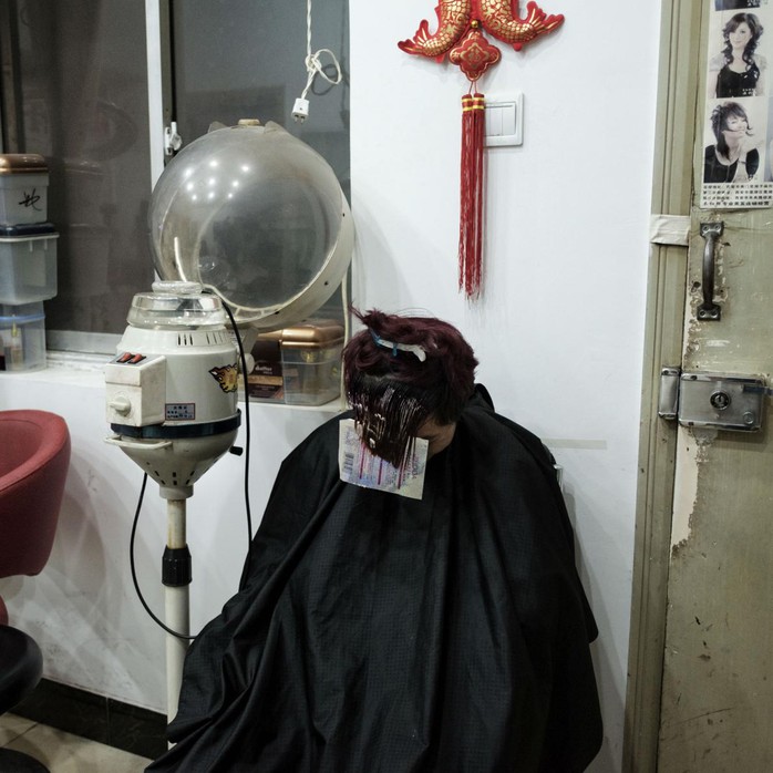 
Một chàng trai nhuộm tóc tại một hiệu làm tóc dưới lòng đất. Ảnh: Antonio Faccilongo
