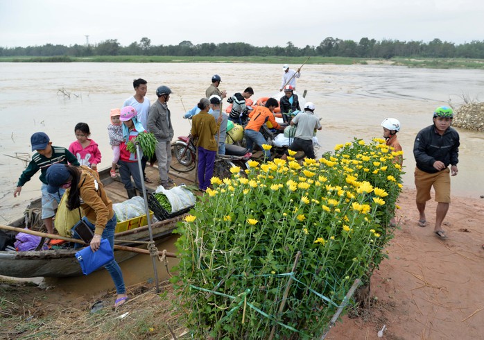 Nước sông dâng cao chia cắt con đường qua thôn An Phú, xã Tịnh An, TP Quảng Ngãi trong sáng 27-1. Ảnh: Tử Trực
