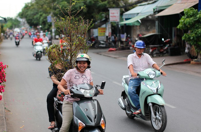 Người dân cười tươi vui vẻ khi mua được một cây mai ưng ý