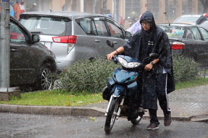 
Trong cơn mưa giông, nam thanh niên dắt xe đi tìm chỗ trú.
