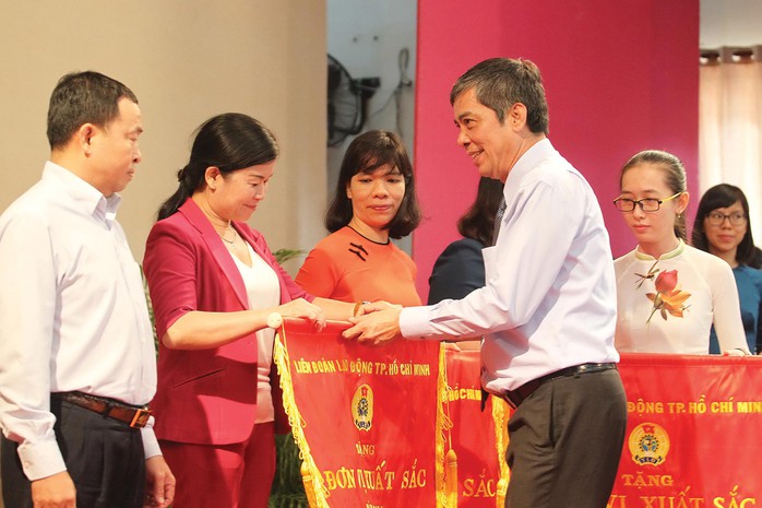 Ông Nguyễn Văn Khải, Phó Chủ tịch Thường trực LĐLĐ TP HCM, tặng cờ thi đua xuất sắc cho các đơn vị tiêu biểu Ảnh: HOÀNG TRIỀU