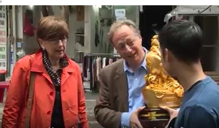 Sau khi mua được bức tượng gà cho năm mới, Đại sứ, Trưởng đại diện Phái đoàn Liên minh châu Âu tại Việt Nam Bruno Angelet bê nó đi cùng khắp phiên chợ - Ảnh: Đại sứ mặc cả mua một cây quất trong phiên chợ
