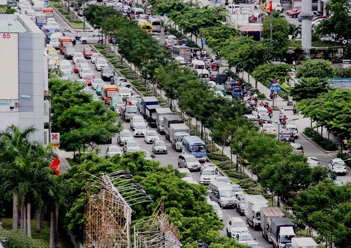 
Còn bên ngoài, dòng ô tô cũng nối đuôi nhau kéo dài, trong khi xe máy phải luồn lách giữa các hàng ô tô hoặc leo lên vỉa hè để lưu thông.
