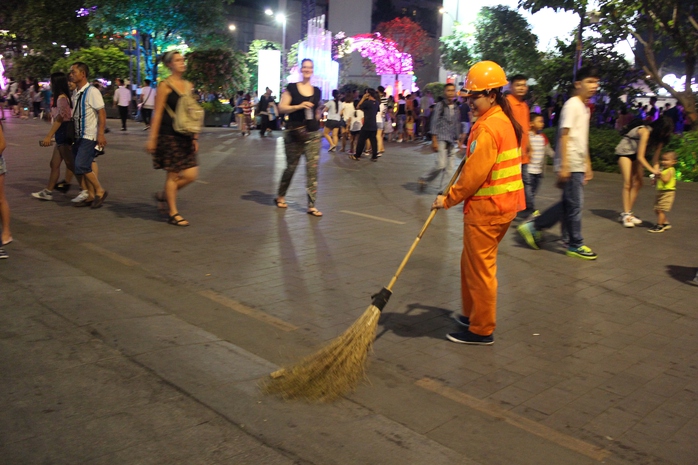 Công nhân vệ sinh làm việc tại Đường hoa Nguyễn Huệ trong đêm giao thừa