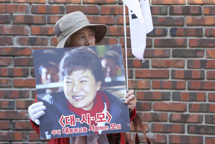 Một người ủng hộ bà Park Geun-hye trước nhà riêng của bà ở thủ đô Seoul ngày 15-3 Ảnh: AP