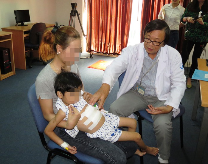 
Bác sĩ Đào Trung Hiếu đang kiểm tra lại vết mổ cho bé T. - ẢNH: ANH THƯ
