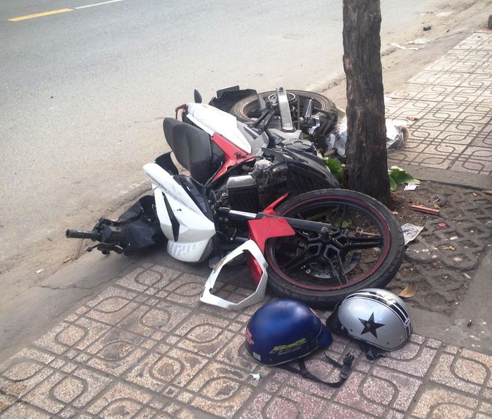 
Chiếc xe máy nằm chỏng chơ dưới gốc cây ven đường sau cú tông
