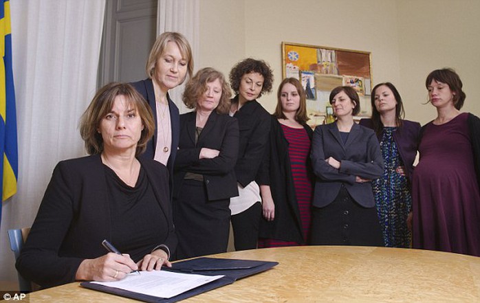 
Phó thủ tướng Thụy Điển ký kết văn bản về biến đổi khí hậu, xung quanh bà là các thành viên chính phủ. Ảnh: AP
