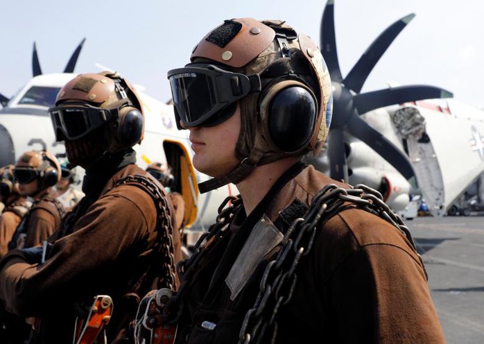 
Các nhân viên của Hải quân Mỹ trên tàu sân bay USS Carl Vinson theo dõi chiến đấu cơ F18 cất cánh. Ảnh: Reuters
