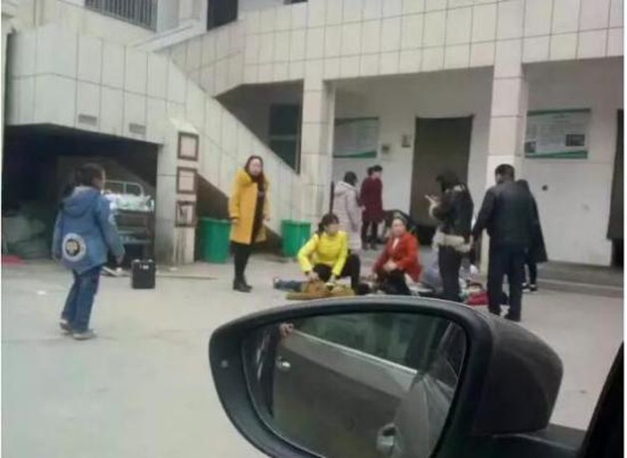 Các em học sinh bị thương nằm ở sân trường. Ảnh: CHINA NEWS