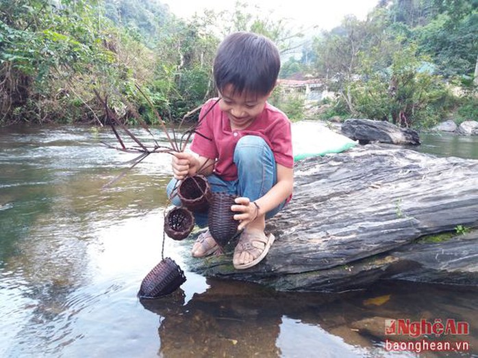 
Còn các em nhỏ cũng tranh thủ thả mang xay moi (một dụng cụ săn cá và nòng nọc truyền thống của người Thái) để đặt vào ban ngày
