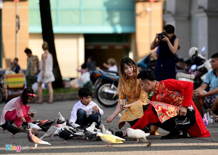 
Trước cửa nhà thờ Đức Bà, khách du lịch tham quan trong cảnh thanh bình. Nhiều bạn trẻ diện áo dài cách tân chụp hình với đàn bồ câu
