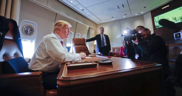 Ông Trump ngồi tại bàn làm việc trên chiếc Air Force One hôm 26-1. Ảnh: AP