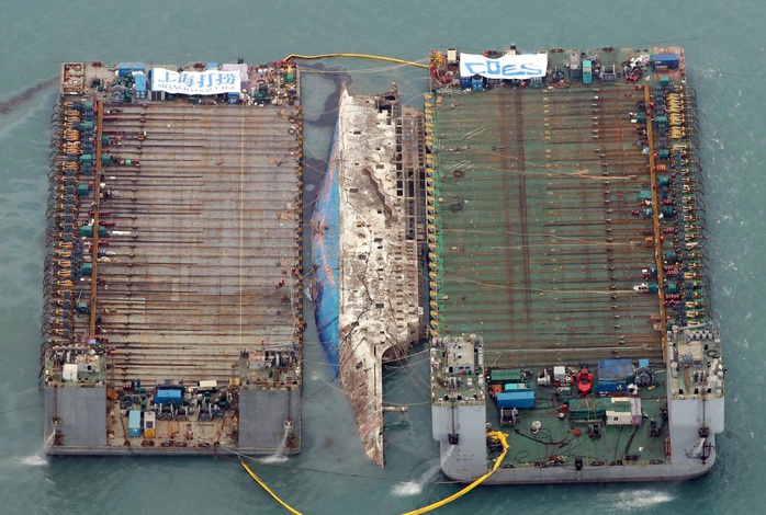 Hai sà lan nâng phà Sewol từ độ sâu 40 m ngoài khơi đảo Jindo ở Hàn Quốc lên mặt biển ngày 23-3. Ảnh: YONHAP