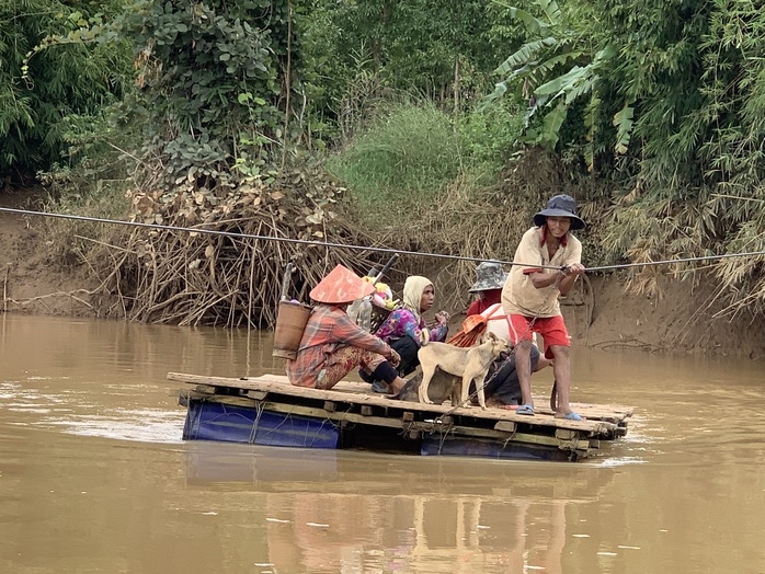 Cầu treo lỡ dở, dân liều mình kéo bè qua nước lũ - Ảnh 2.