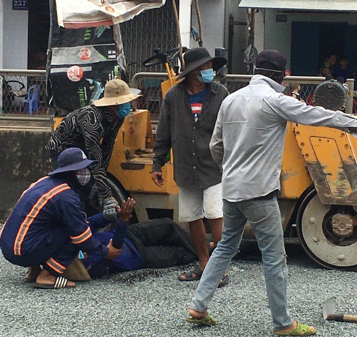 Một công nhân sửa chữa đường bị xe lu cán qua người - Ảnh 1.