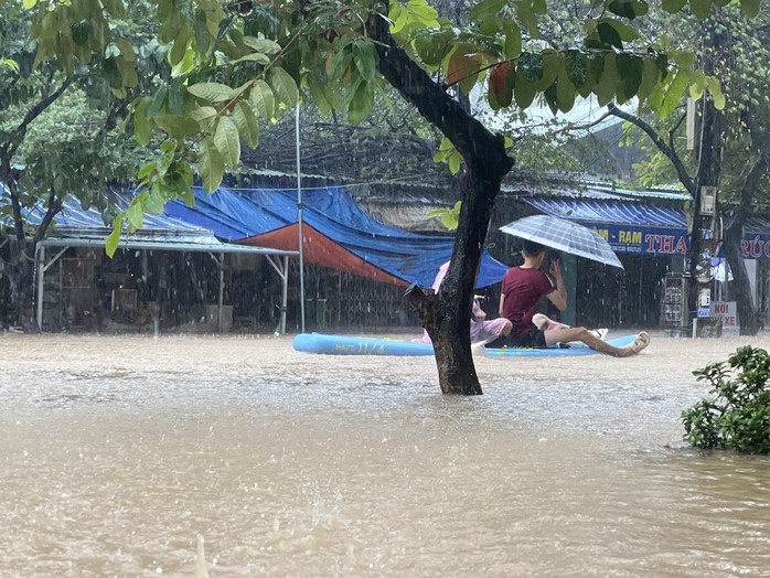 Quy Nhơn: 2 ngày mưa lớn, người dân dùng thuyền di chuyển qua chỗ ngập - Ảnh 1.