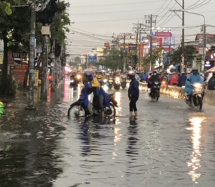 CLIP: Mưa lớn giờ tan tầm, người dân quận 12, TP HCM bì bõm lội nước về nhà - Ảnh 4.