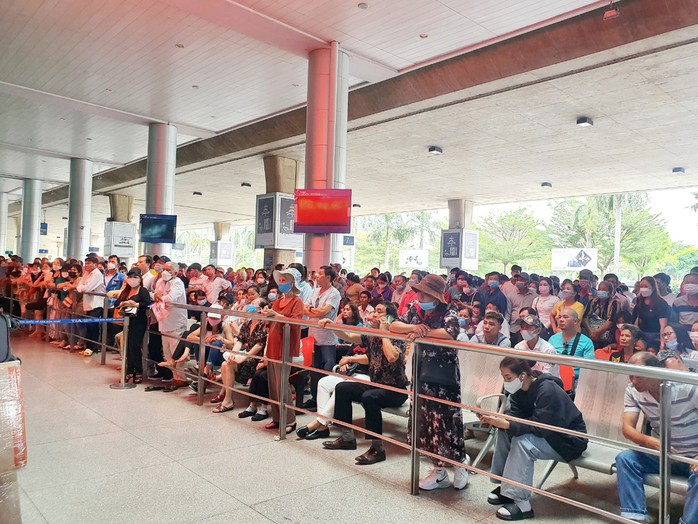 Hàng ngàn người đứng, ngồi ở sân bay Tân Sơn Nhất chờ đón Việt kiều - Ảnh 3.