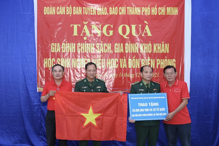 Đại diện đoàn cán bộ tuyên giáo, báo chí, xuất bản TP HCM trao tặng quà, cờ Tổ quốc cho gia đình chính sách, gia đình khó khăn, học sinh nghèo hiếu học và đồn biên phòng trên địa bàn tỉnh Điện Biên Ảnh: HOÀNG TRIỀU