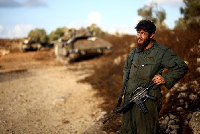 Một người lính Israel bên cạnh chiếc xe tăng của quân đội Israel gần biên giới với Lebanon. Ảnh: Reuters Một người lính Israel bên cạnh chiếc xe tăng của quân đội Israel gần biên giới với Lebanon. Ảnh: Reuters