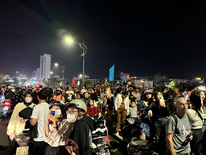 Đà Nẵng: Người dân tắm mưa, xem cầu Rồng phun lửa đón năm mới 2024- Ảnh 4. Đà Nẵng: Người dân tắm mưa, xem cầu Rồng phun lửa đón năm mới 2024- Ảnh 4.