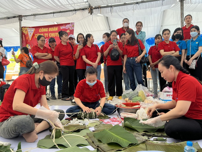 Công nhân hào hứng gói bánh chưng, bánh tét tại chương trình "Xuân rộn ràng"- Ảnh 1. Công nhân hào hứng gói bánh chưng, bánh tét tại chương trình "Xuân rộn ràng"- Ảnh 1.