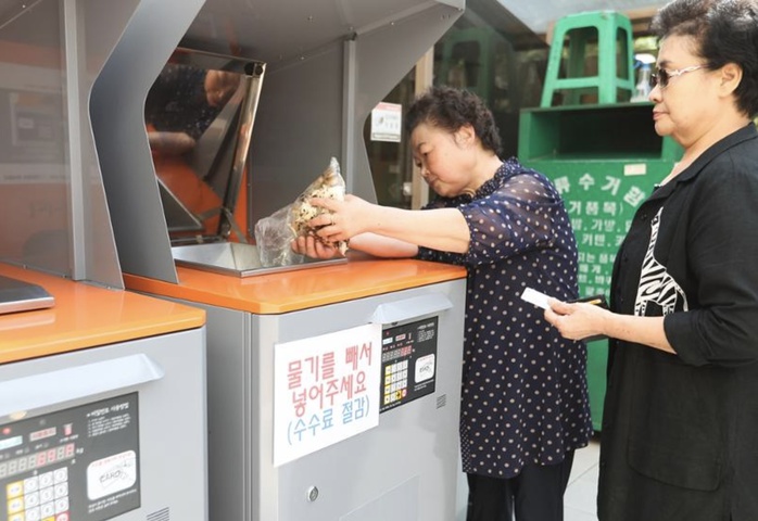 Người dân bỏ rác thải thực phẩm vào thùng rác có tính năng tính trọng lượng tại thủ đô Seoul - Hàn QuốcẢnh: YONHAP Người dân bỏ rác thải thực phẩm vào thùng rác có tính năng tính trọng lượng tại thủ đô Seoul - Hàn QuốcẢnh: YONHAP
