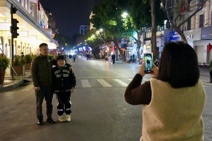 Dòng người đổ về hồ Gươm xem bắn pháo hoa chào đón năm mới- Ảnh 6. Dòng người đổ về hồ Gươm xem bắn pháo hoa chào đón năm mới- Ảnh 6.