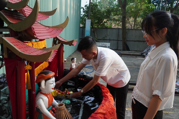 Huỳnh Minh Thuận bên mô hình robot múa rối nước Huỳnh Minh Thuận bên mô hình robot múa rối nước