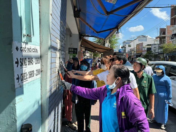 Cặp đôi nghệ sĩ Thành Đạt và Hải Băng xuống đường bóc xóa quảng cáo sai quy định- Ảnh 1.