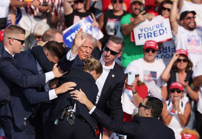 Cựu Tổng thống Donald Trump được nhân viên Sở Mật vụ che chắn, hộ tống sau vụ nổ súng ở TP Butler, bang Pennsylvania - Mỹ Ảnh: REUTERS Cựu Tổng thống Donald Trump được nhân viên Sở Mật vụ che chắn, hộ tống sau vụ nổ súng ở TP Butler, bang Pennsylvania - Mỹ Ảnh: REUTERS