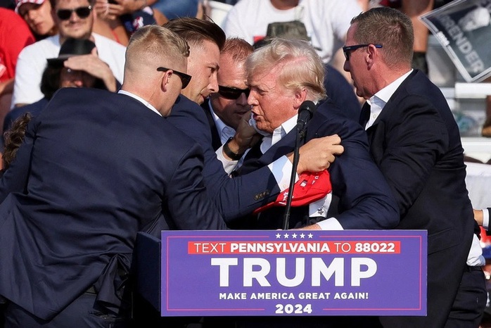 Ông Trump được các mật vụ vây quanh đưa khỏi sân khấu sau khi bị bắn. Ảnh: Reuters Ông Trump được các mật vụ vây quanh đưa khỏi sân khấu sau khi bị bắn. Ảnh: Reuters