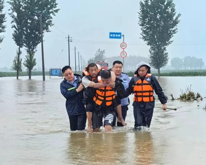 Ngày 15-7, cảnh sát TP Nam Dương giúp những người bị mắc kẹt không thể đi lại vì bệnh tật. Ảnh: tkww.hk Ngày 15-7, cảnh sát TP Nam Dương giúp những người bị mắc kẹt không thể đi lại vì bệnh tật. Ảnh: tkww.hk
