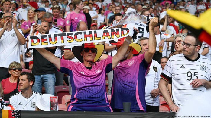 Người hâm mộ đến sân vận động với áo đấu màu hồng cùng chiếc khăn in chữ “Deutschland” Người hâm mộ đến sân vận động với áo đấu màu hồng cùng chiếc khăn in chữ “Deutschland”
