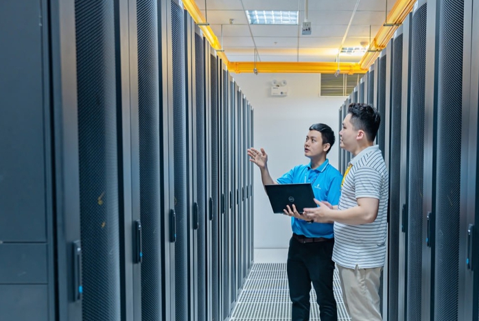 Hệ sinh thái VNPT Cloud: Hướng tới tương lai kết nối toàn diện- Ảnh 3. A person standing in a hallway with a computer Description automatically generated