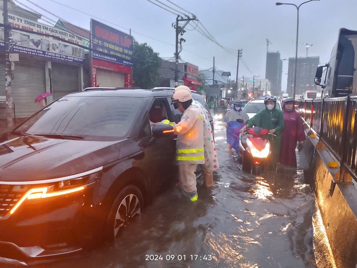 Mưa lớn ở TP HCM, cảnh sát giao thông lội nước cùng tài xế đẩy ô tô chết máy - Ảnh 1. Mưa lớn ở TP HCM, cảnh sát giao thông lội nước cùng tài xế đẩy ô tô chết máy - Ảnh 1.
