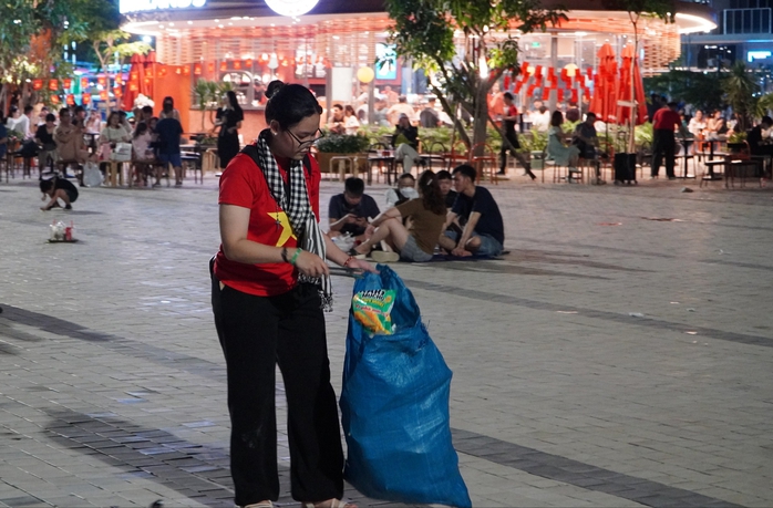 Nhóm bạn trẻ mặc áo cờ đỏ sao vàng, tình nguyện nhặt rác trong đêm pháo hoa- Ảnh 1. Nhóm bạn trẻ mặc áo cờ đỏ sao vàng, tình nguyện nhặt rác trong đêm pháo hoa- Ảnh 1.
